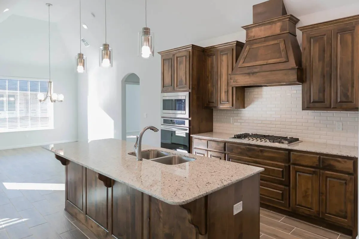 Kitchen with a wood hood and stone counters in a Kingdom Homes house